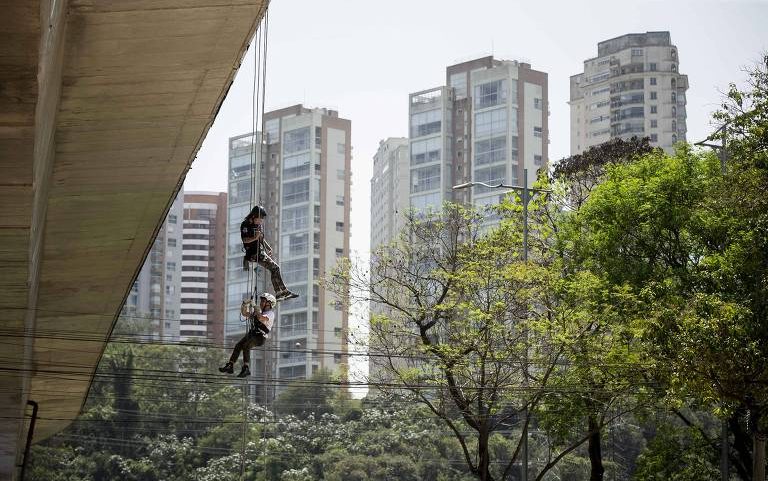 Criança e instrutor fazem rapel na Vertical Infinity, em São Paulo