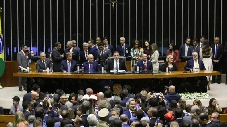 Lula (sentado entre Arthur Lira e Rodrigo Pacheco) durante sessão solene do Congresso em que foi empossado, em 1º de janeiro