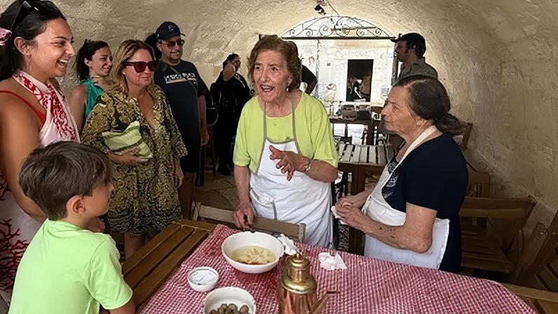 A vovó italiana Teresa Calia recebe clientes para uma visita guiada gastronômica