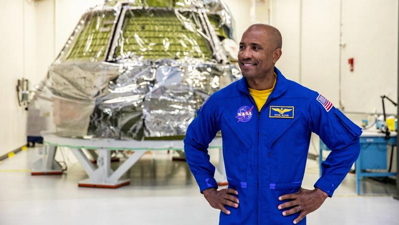 Astronaut Victor Glover stands in front of the Orion capsule that he will pilot around the moon as part of the Artemis 2 mission.