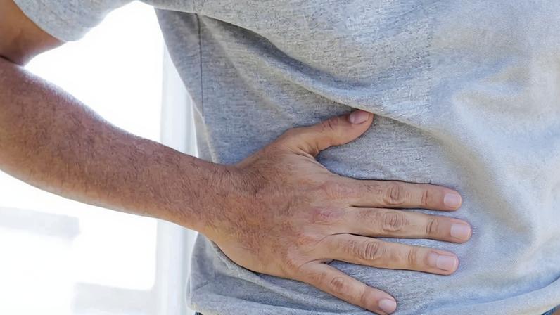 Homem com dor no lado direito da barriga