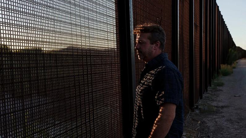 Sami DiPasquale looks through the fence along the US-Mexico border in El Paso, Texas.