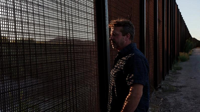 Sami DiPasquale looks through the fence along the US-Mexico border in El Paso, Texas.