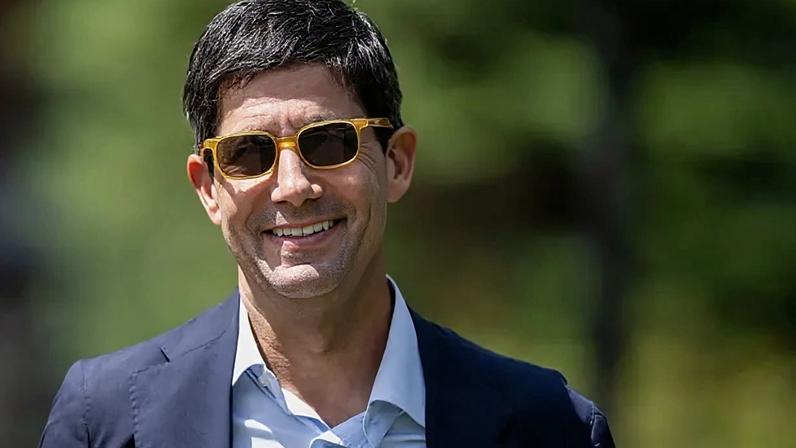 Kevin Warsh wears orange sunglasses, a dark suit and a white shirt