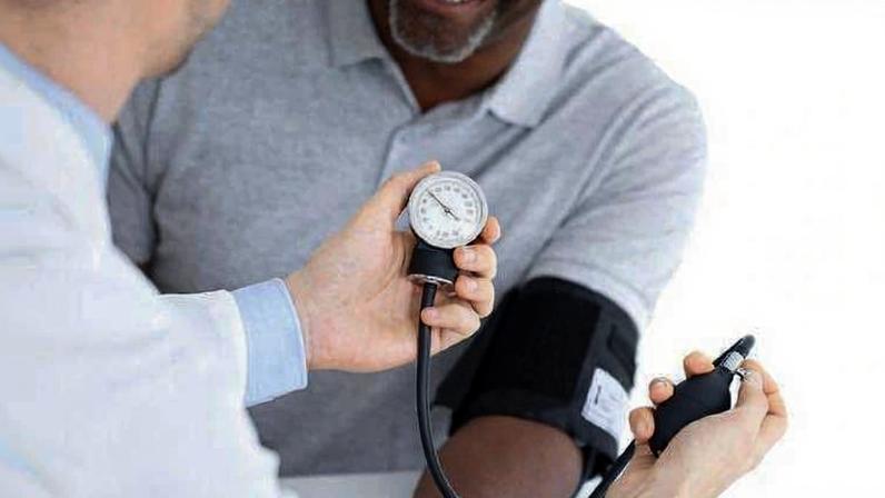Médico medindo pressão arterial de paciente