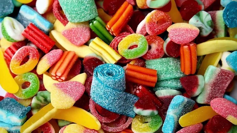 Foto de bala de goma e doces coloridos saborosos como fundo.