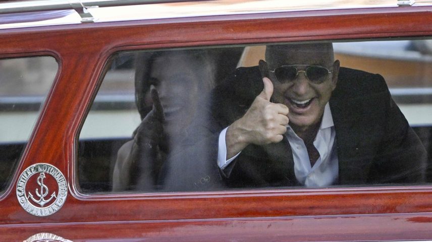 Jeff Bezos, fundador da Amazon, e Lauren Sánchez acenam no táxi aquático no Hotel Aman, em Veneza, cidade onde vão se casar (Foto: ANDREA PATTARO / AFP)