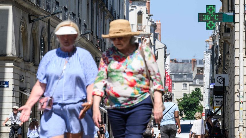 Pessoas caminham pela rua enquanto um termômetro indica temperatura de 36ºC durante onda de calor no centro de Nantes, oeste da França (Foto: Loic Venance/AFP)