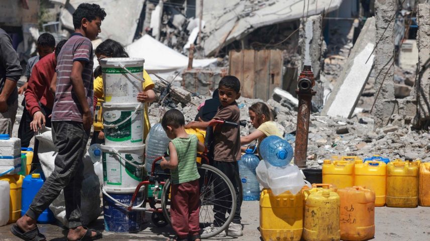 Palestinos fazem fila para encher seus contêineres com água em Rafah, na Faixa de Gaza (Foto: MOHAMMED ABED / AFP)