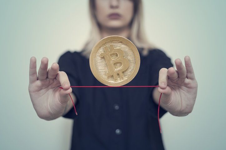 As mãos de uma mulher seguram um Bitcoin de ouro em um fio (Foto: Francesco Carta fotografo/Getty Images)