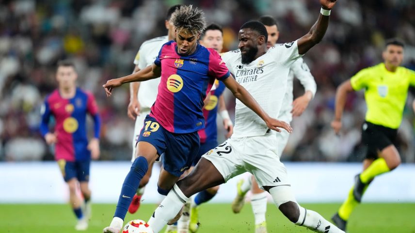 Lamine Yamal (esquerda) regatea a Antonio Rüdiger na final da Supercopa de Espanha. (Foto: NurPhoto via Getty Images)