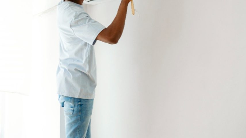 Homem limpa ar condicionado (Foto: Freepik)