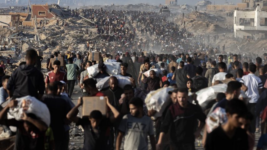 Palestinos carregam pacotes de alimentos doados enquanto outros correm em direção a um ponto de distribuição na Cidade de Gaza (Foto: Saher Alghorra/The New York Times)