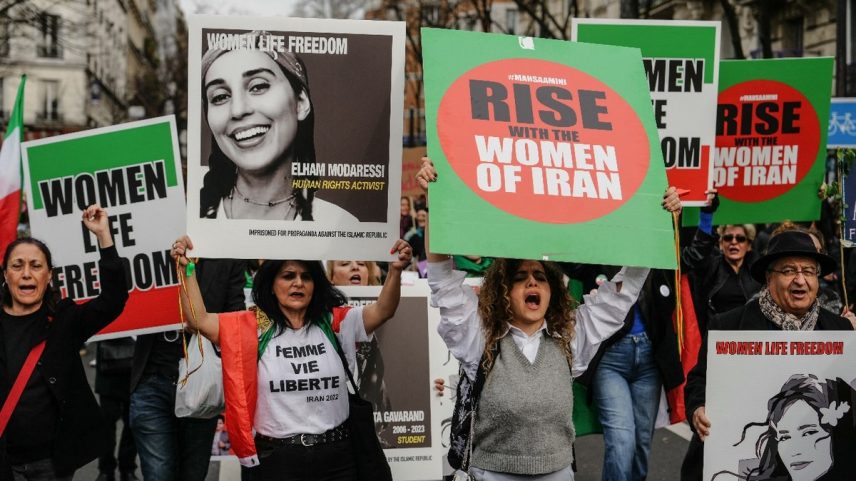 Manifestantes seguram cartazes em apoio ao ativismo das mulheres no Irã (Foto: Dimitar Dilkoff / AFP)