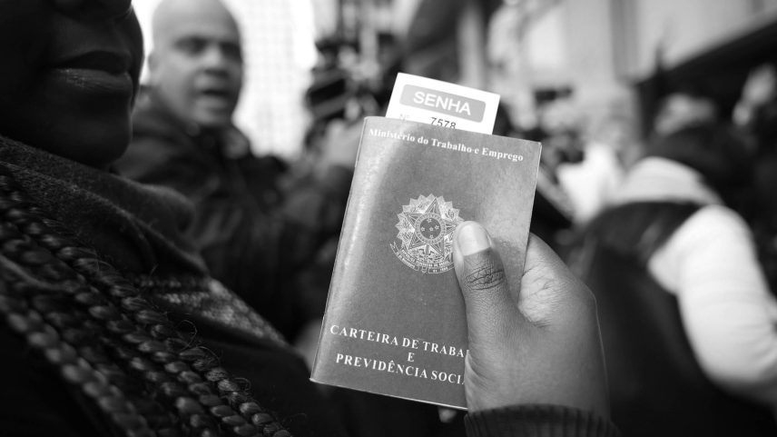 Mulher segura carteira de trabalho em fila de mutirão para emprego, em São Paulo (SP) (Foto: Zanone Fraissat - 1.ago.23/Folhapress)