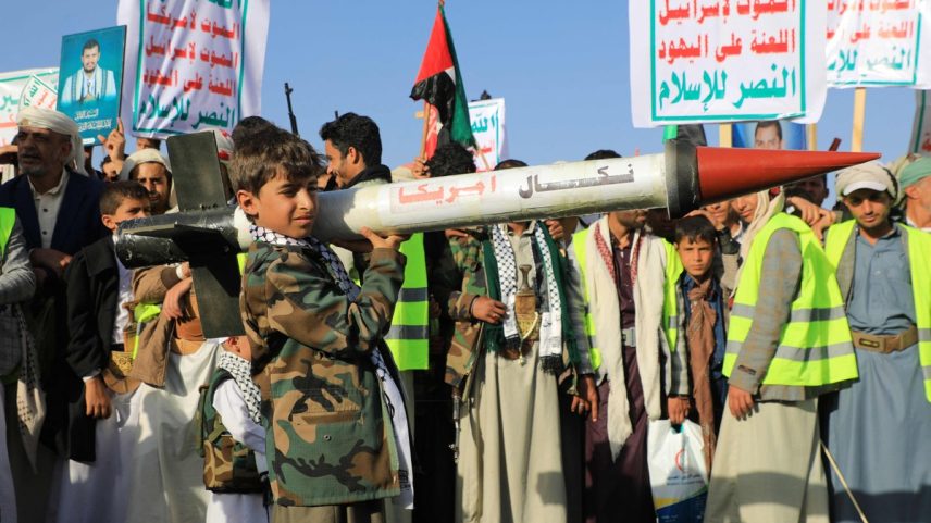 Jovem iemenita segura foguete simulado durante protesto após ataques dos EUA e Reino Unido, na capital Sanaa, controlada pelos Houthis (Foto: AFP)