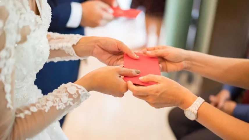 Em muitas culturas asiáticas, os convidados presenteiam os recém-casados com envelopes vermelhos recheados de dinheiro como um sinal de sorte e boa fortuna (Foto: Getty Images)