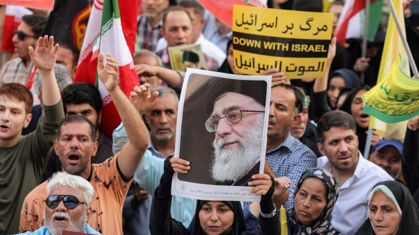 Manifestante levanta foto do líder supremo do Irã, Ali Khamenei, durante protesto em solidariedade ao regime em Teerã (Foto: ATTA KENARE / AFP)