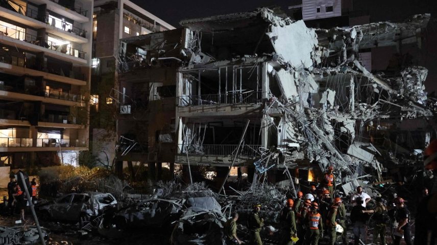 Socorristas buscam feridos após míssil do Irã atingir prédio em Tel Aviv (Foto: Gil COHEN-MAGEN / AFP)