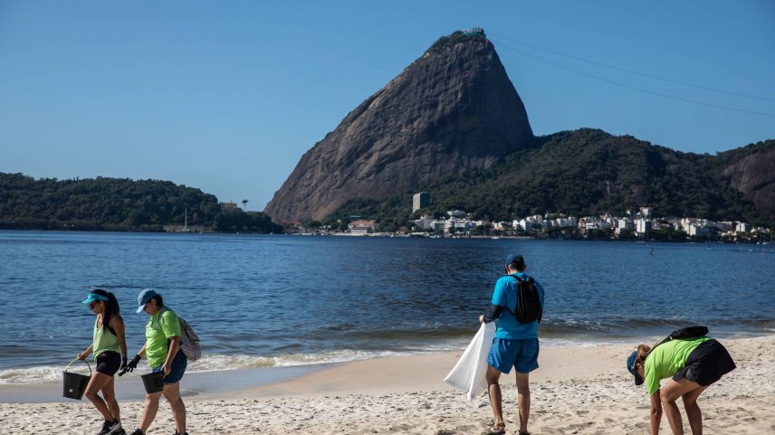 Voluntários recolhem lixo na praia do Flamengo, no Rio de Janeiro, no Dia Mundial da Água (Foto: Wang Tiancong - 22.mar.25/Xinhua)
