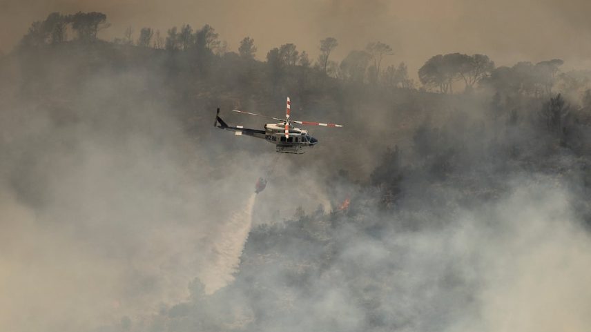 Um helicóptero lança água no incêndio. (Foto: Albert Garcia)