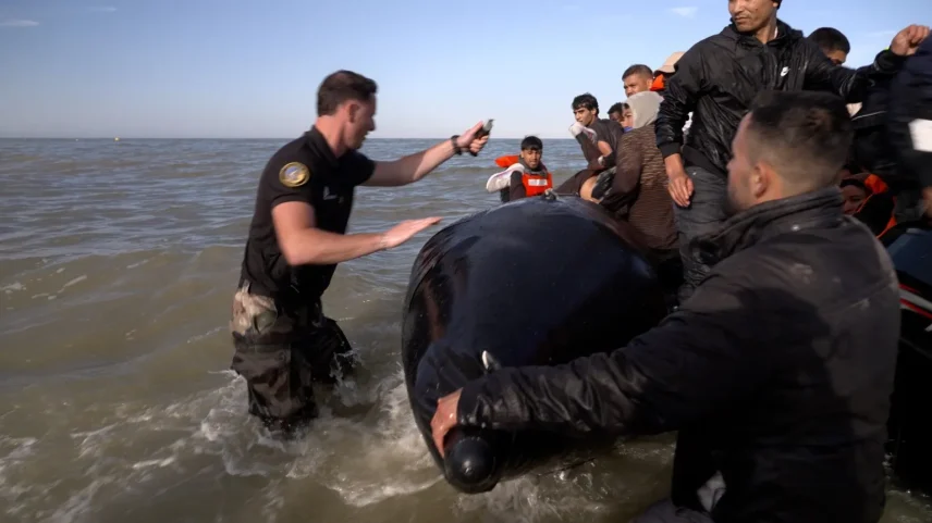 Um policial francês usa uma faca para cortar um barco inflável com migrantes no Canal da Mancha (Foto: Reprodução)