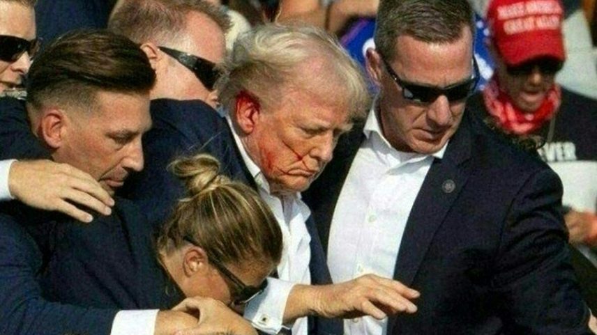 Donald Trump é retirado de palco de comício, sangrando, por agentes do serviço secreto dos EUA (Foto: Rebecca Droke/AFP)