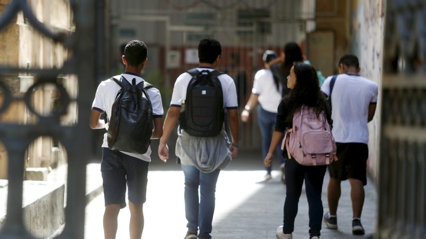 Estudantes atravessam portão de escola pública no Rio de Janeiro (Foto: Fabiano Rocha/Extra)