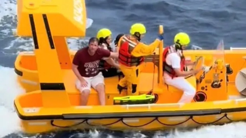 O pai (na foto com uma camisa vermelha) imediatamente mergulhou cerca de 15 metros no oceano para salvar sua filha (Foto: Reprodução/Facebook)