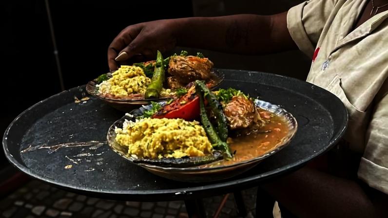 O frango caipira cozido com arroz, feijão manteiga e angu sendo servido nas mesas ao longo do Beco das Sardinhas