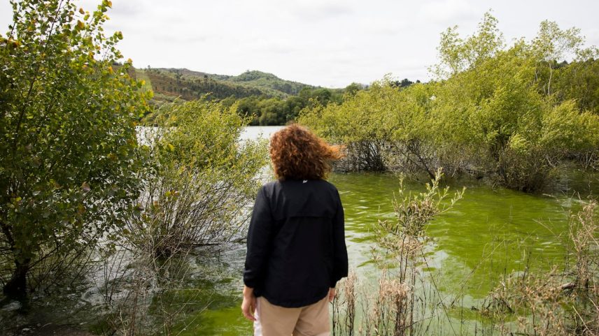 Uma vizinha contempla a água contaminada por cianobactérias em As Conchas (Lobeira). (Foto: ÓSCAR CORRAL)