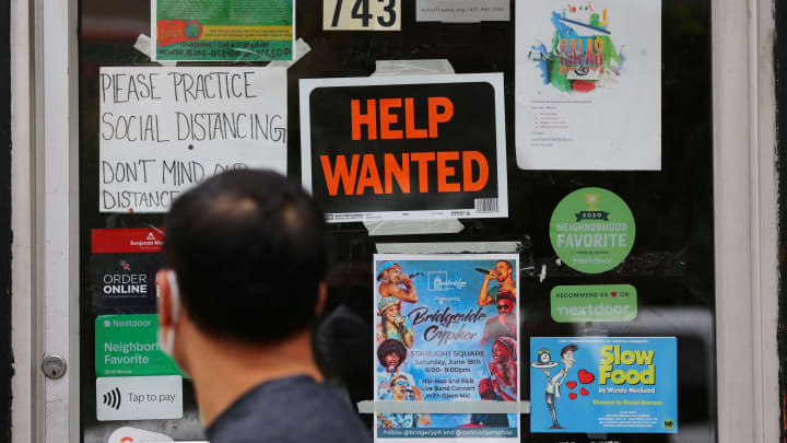 Um pedestre passa por um cartaz de "Ajuda Necessária" na porta de uma loja de ferramentas em Cambridge, Massachusetts, EUA, 8 de julho de 2022. (Foto: Brian Snyder | Reuters)