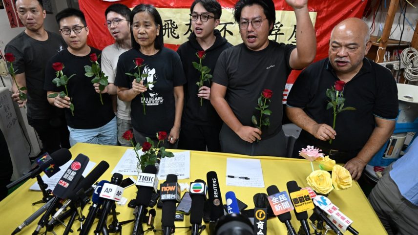 Membros da Liga dos Sociais-Democratas, com o líder Chan Po-ying (C), gritam slogans após uma coletiva de imprensa em sua sede em Hong Kong, em 29 de junho de 2025 (Foto: Peter PARKS/AFP)