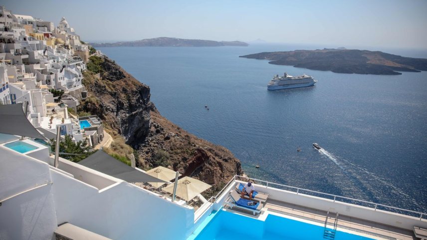 Navios de cruzeiro e piscinas com vista para o mar, uma constante em Oia, na ilha de Santorini, na Grécia (Foto: Aris Oikonomou / AFP)