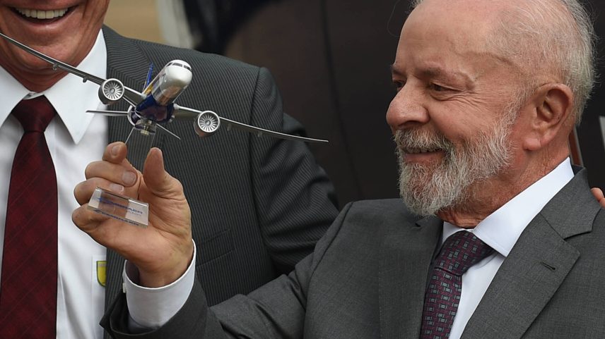 O presidente Lula segura uma réplica de uma aeronave fabricada pela fabricante brasileira Embraer (Foto: Lucio Tavora/Xinhua)