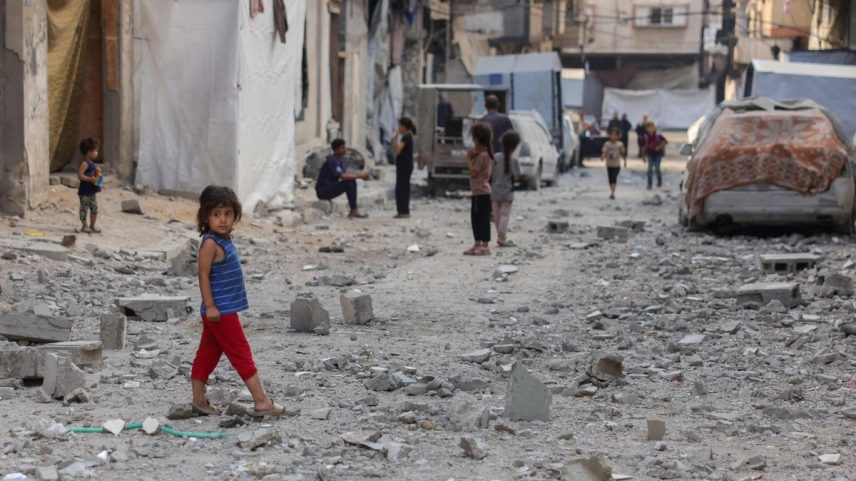 Crianças palestinas caminham em ruas cobertas por escombros de edifício atingido por ataques israelenses, na Cidade de Gaza (Foto: Bashar Taleb / AFP)