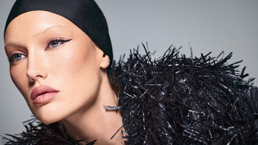 Fundo de maquiagem mate Forever da DIOR, corretor Revealer Concealer da KOSAS, colorete Make Me Blush da YVES SAINT LAURENT e, nos olhos, delineador Better Than Sex da TOO FACED e máscara de pestañas Lash Idôle da LANCÔME. Os lábios são delineados e coloridos com Pillow Talk Duo Set da CHARLOTTE TILBURY. Meredith usa uma jaqueta de rafia da MICHAEL KORS e uma diadema negra da estilista Michael Schwartz. (Foto: Reprodução)