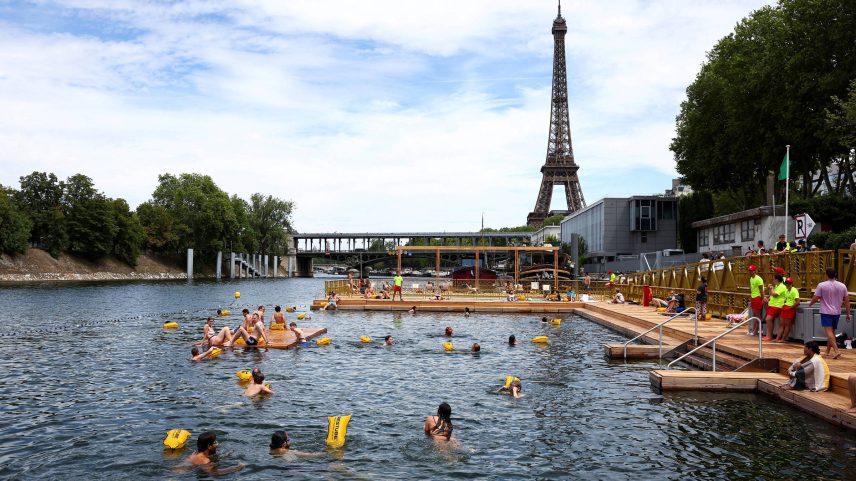 Pessoas pulam no rio Sena, diante da torre Eiffel, no primeiro dia de liberação para banho público (Foto: Abdul Saboor - 5.jul.25/Reuters)