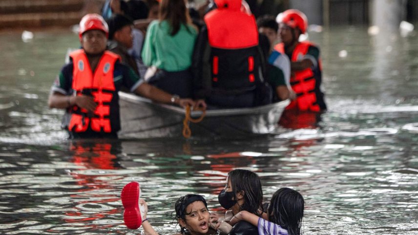 Pessoas nadam em meio à enchente em uma rua de Manila (Foto: Ted ALJIBE / AFP)