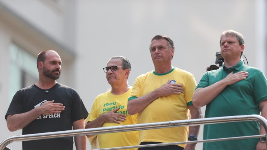 Eduardo Bolsonaro, em manifestação na Avenida Paulista, olha para Tarcísio de Freitas, hoje seu desafeto (Foto: Tiago Queiroz/Estadão)