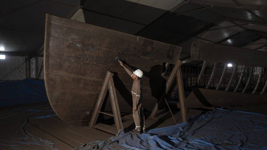 Trabalhador acompanha o processo de restauração do barco histórico encontrado nas obras da Nova Doca, no centro de Belém, como parte da preparação para a COP30 (Foto: Alessandro Falco/Folhapress)