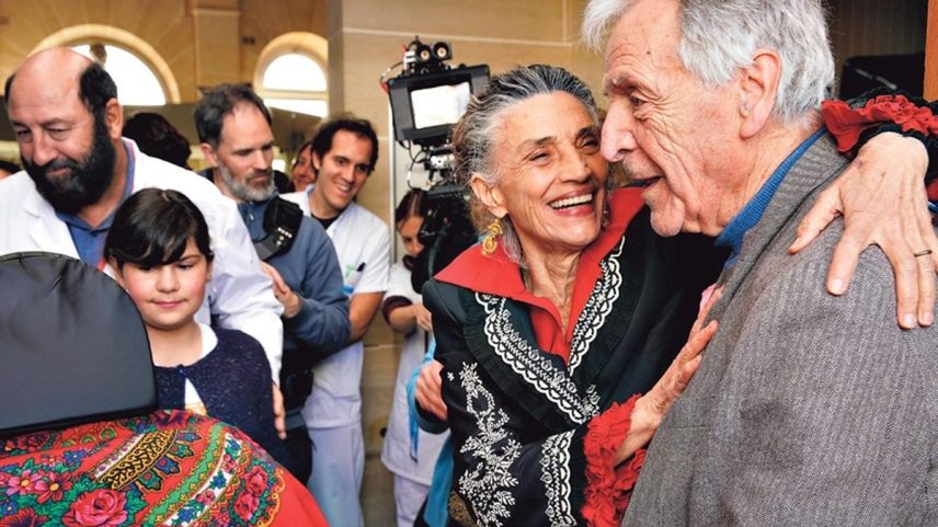 Uma família de ciganos se despede da matriarca cantando e dançando para ela, que é vivida por Angela Molina, na foto com Costa-Gavras (Foto: Divulgação)