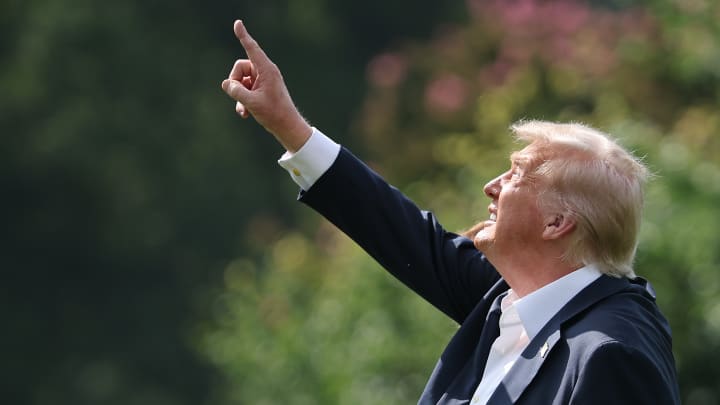 Donald Trump aponta para um mastro de bandeira recém-instalado enquanto deixa a Casa Branca em 11 de julho de 2025, em Washington, D.C. (Foto: Win McNamee | Getty Images)