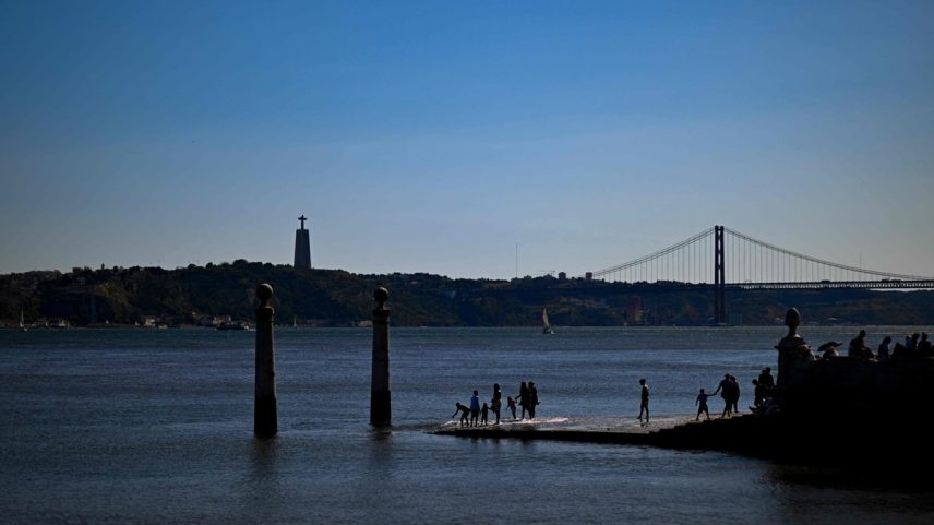 Pessoas caminham pelo Cais das Colunas, na margem do Rio Tejo, em Lisboa (Foto: Patrícia de Melo Moreira/AFP/Agosto-2023)