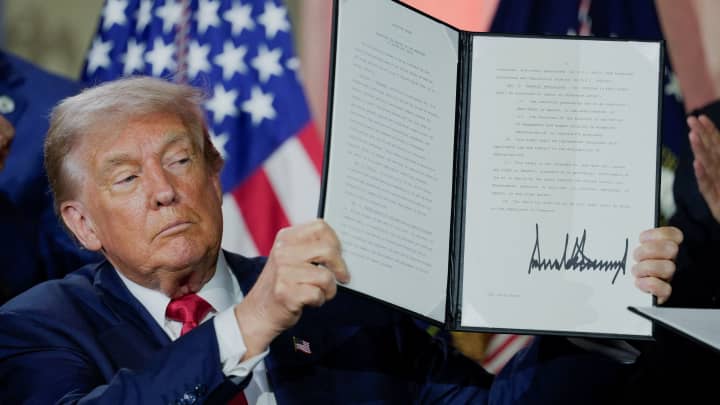 O presidente dos EUA, Donald Trump, segura uma ordem executiva relacionada à IA após assiná-la durante a Cúpula "Vencendo a Corrida da IA" em Washington D.C., EUA, em 23 de julho de 2025. (Foto: Kent Nishimura | Reuters)