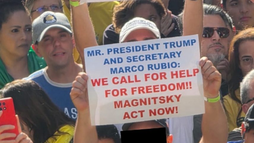 Foto de bolsonaristas erguendo cartazes em inglês pedindo a Donald Trump e Marco Rubio sanções dos EUA contra Alexandre de Moraes foi compartilhada por Eduardo Bolsonaro (PL-SP) e outros bolsonaristas omitindo rosto de manifestante nas redes sociais (Foto: Reprodução)