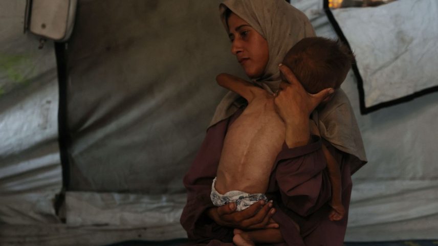 Hidaya, mãe palestina de 31 anos, segura seu bebê doente de 18 meses, Mohammed al-Mutawaq, que também tem sinais de desnutrição, dentro de sua tenda no campo de refugiados de Al-Shati, a oeste da Cidade de Gaza — Foto: Omar AL-QATTAA / AFP/ 24-7-2025