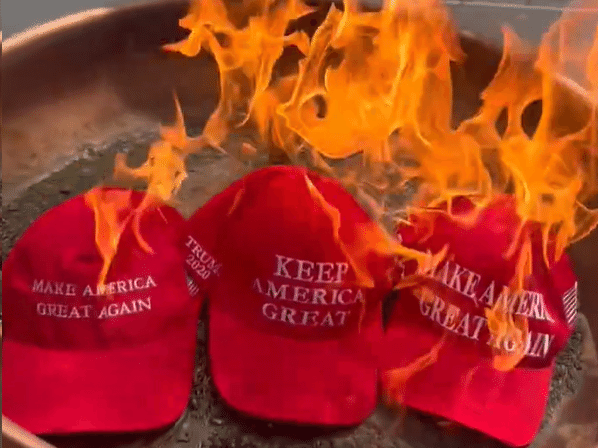 Bonés com o slogan "make America great again" sendo queimados (Foto: Reprodução/X)