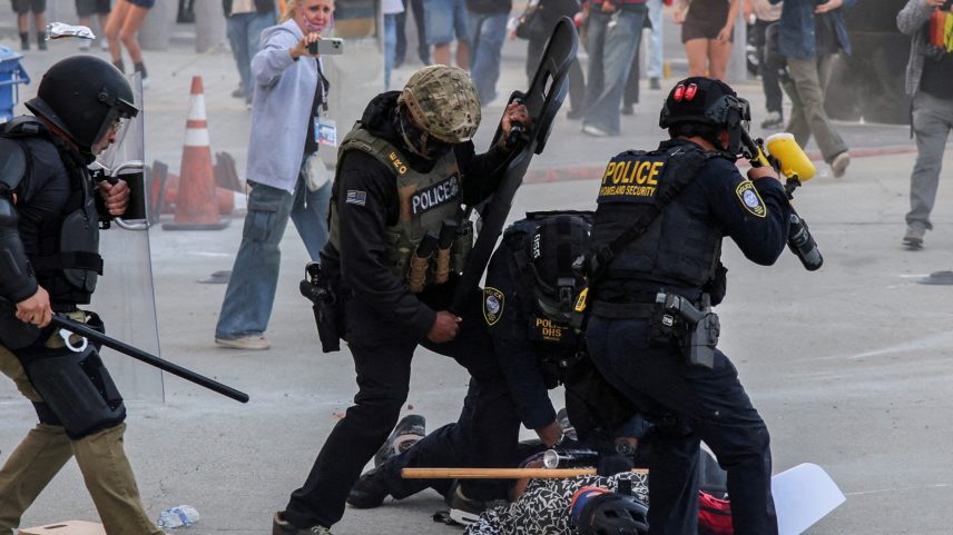 Polícia detém manifestante que bloqueava a entrada da garagem do Edifício Federal de Los Angeles após várias detenções pelo Serviço de Imigração e Alfândega (Foto: Daniel Cole/Reuters)