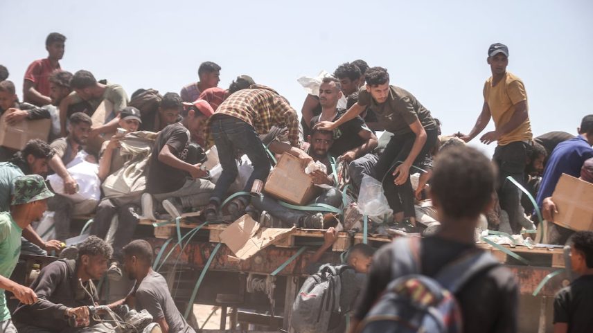 Palestinos, à beira da inanição devido aos ataques e ao bloqueio do exército israelense, se reúnem em um ponto de distribuição de ajuda no Corredor Netzarim para acessar um suprimento limitado de farinha na Faixa de Gaza, nesta quarta-feira. (Foto: Anadolu via Getty Images)